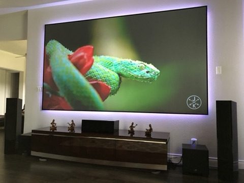 Backlit home theater display wall with floor-standing speakers